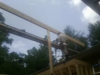 Carpenter setting a ridge beam over a new addition frame — Ice Dam Removal by Roofing Brothers in Apalachin