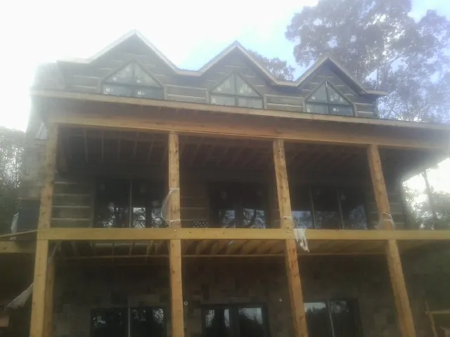 Dormers and porch framing on a large log home under construction — Roof Coating work by our crew in Apalachin