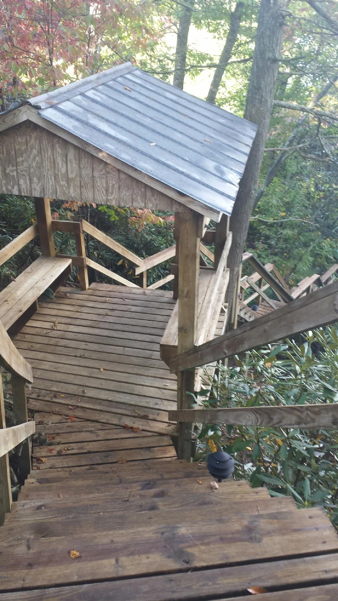 Metal roofed shelter over wooden steps on a wooded walkway — Skylight Repair & Installation work by our crew in Apalachin